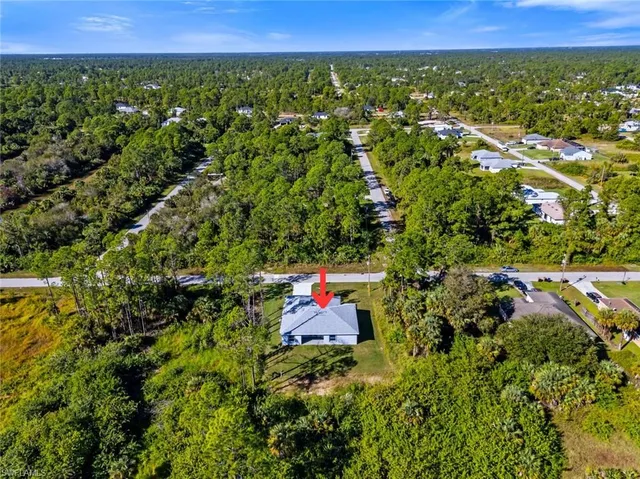 an aerial view of residential house with outdoor space and trees around