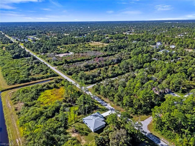an aerial view of residential houses with outdoor space and trees