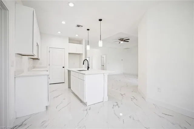 a view of a kitchen with white cabinets