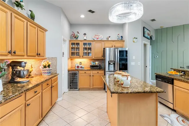 a kitchen with stainless steel appliances granite countertop a sink refrigerator and cabinets