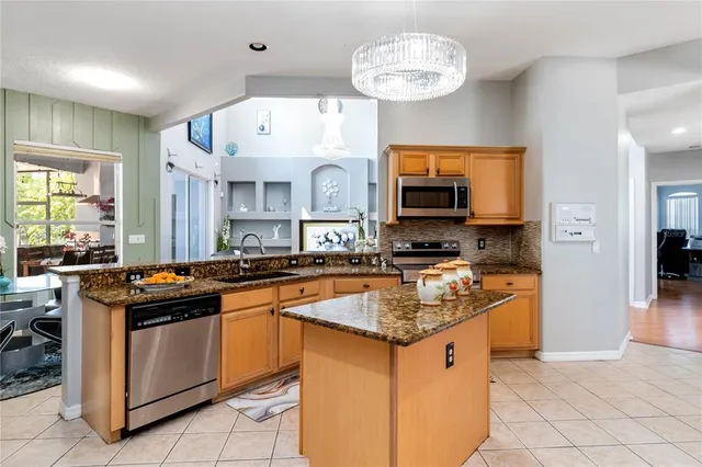 a large kitchen with kitchen island granite countertop a large counter top and stainless steel appliances