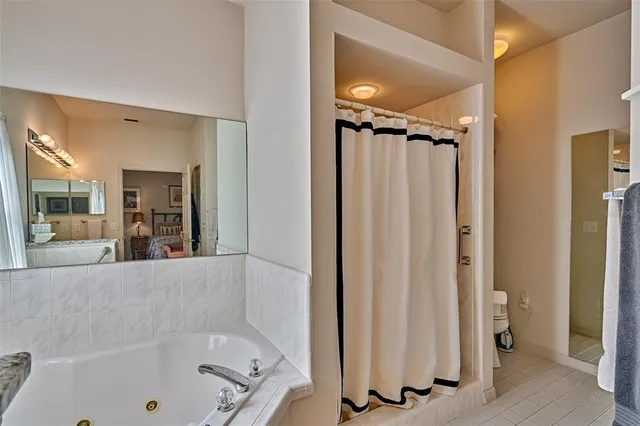 a bathroom with a tub a mirror and a shower