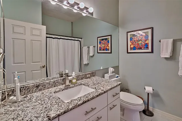 a bathroom with a granite countertop sink and a mirror