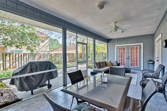 a living room with furniture a flat screen tv and a floor to ceiling window