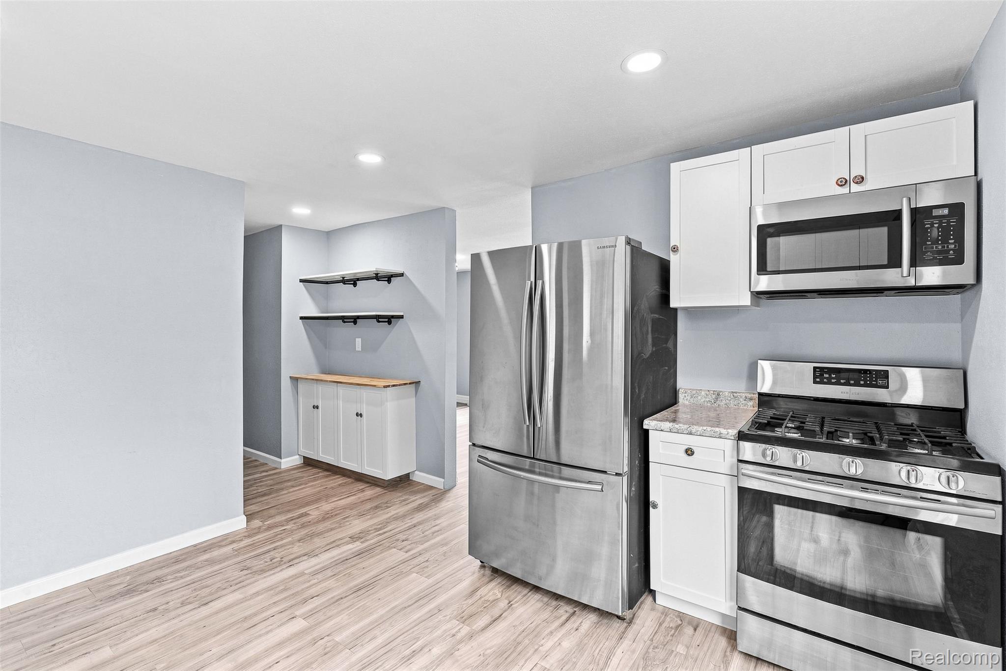 6163 North State Road Davison, MI 48423 - Photo 21 of 45 Contemporary kitchen featuring stainless steel appliances, white cabinetry, and granite-look countertops
