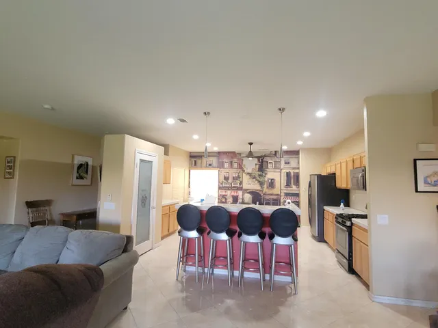 a living room with furniture kitchen view and a refrigerator