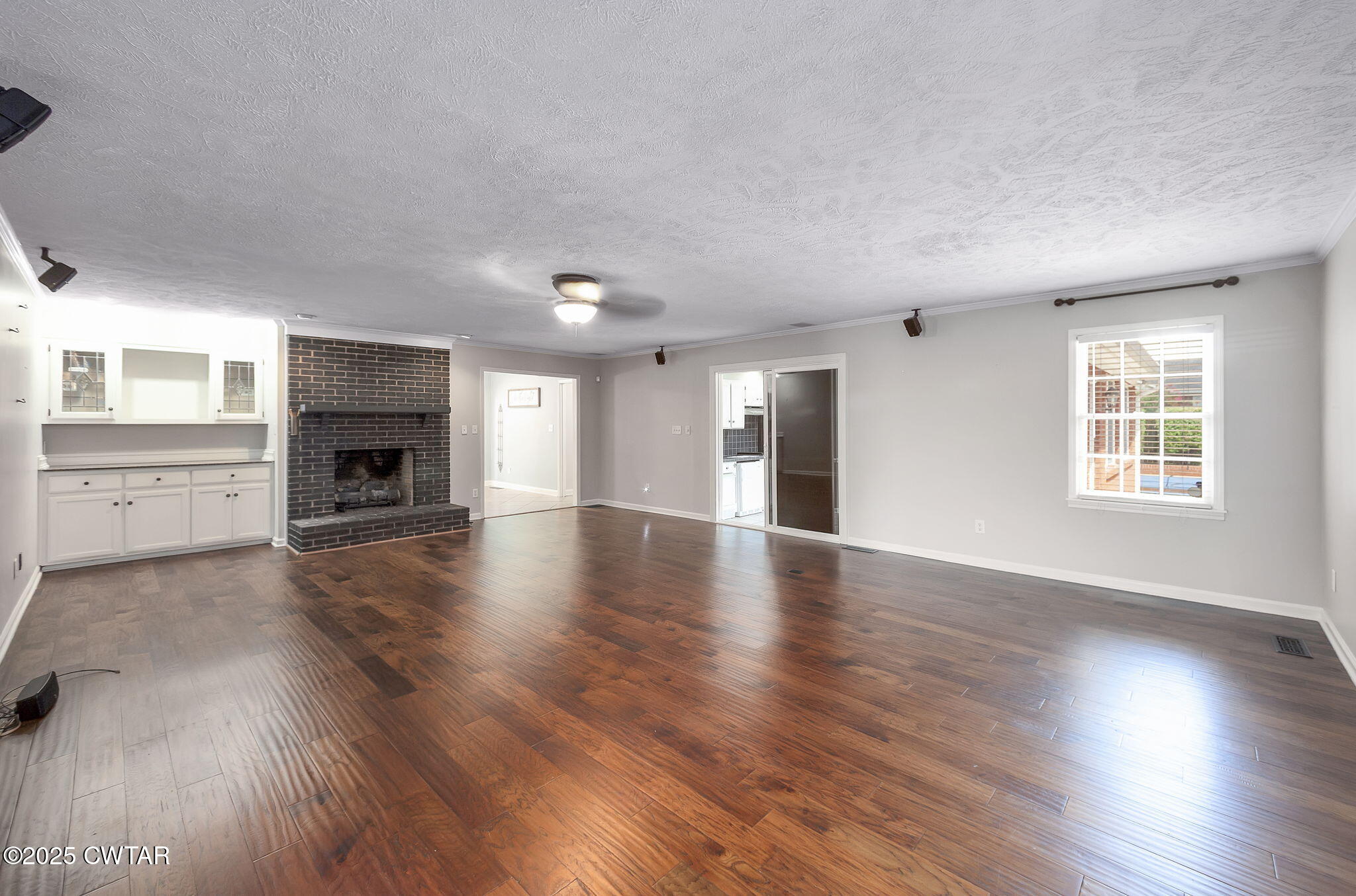 6 Jamestown Drive Jackson, TN 38305 - Photo 18 of 32 an empty room with wooden floor fireplace and windows