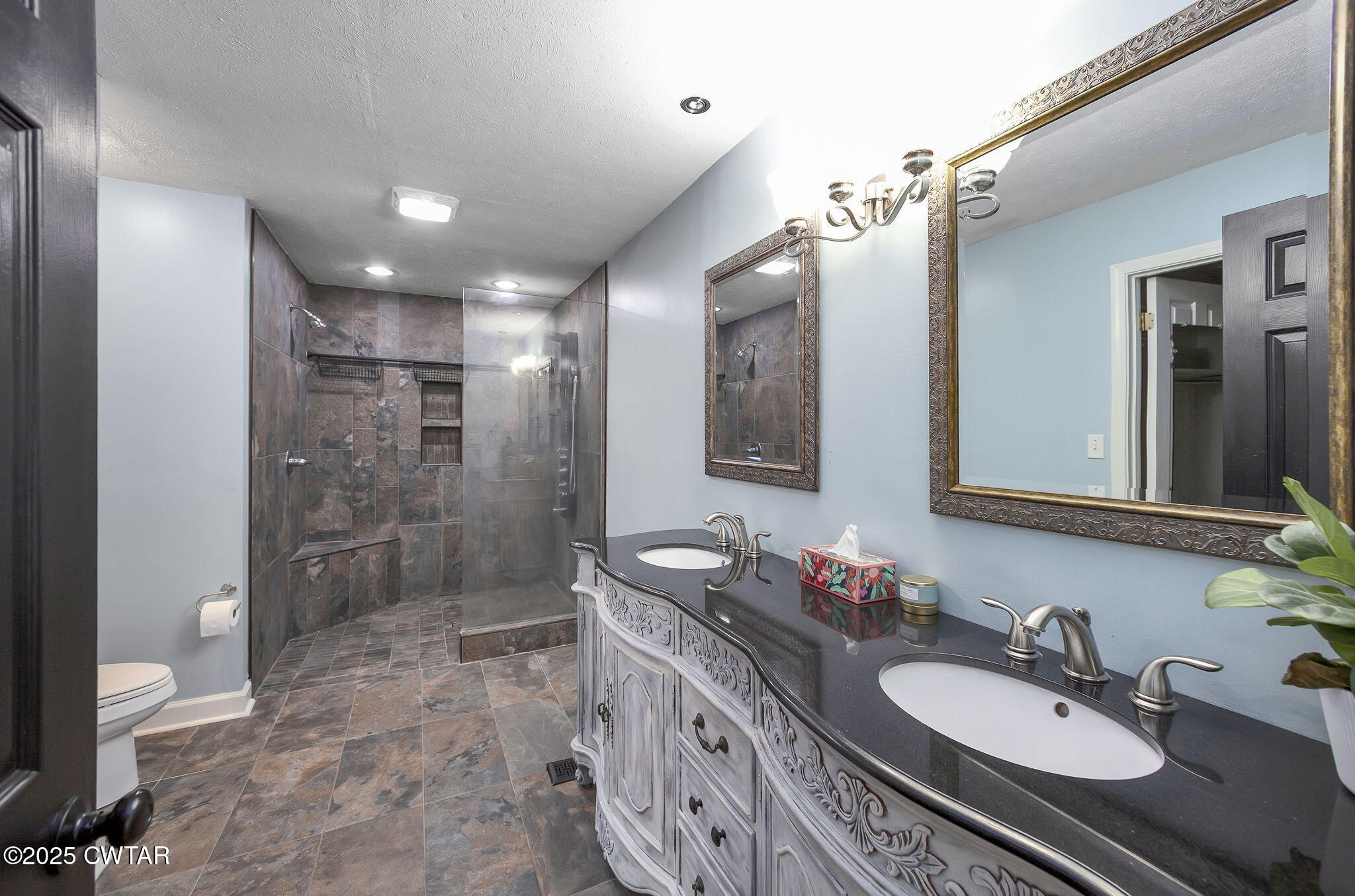 6 Jamestown Drive Jackson, TN 38305 - Photo 24 of 32 a bathroom with a granite countertop sink a toilet a mirror and shower