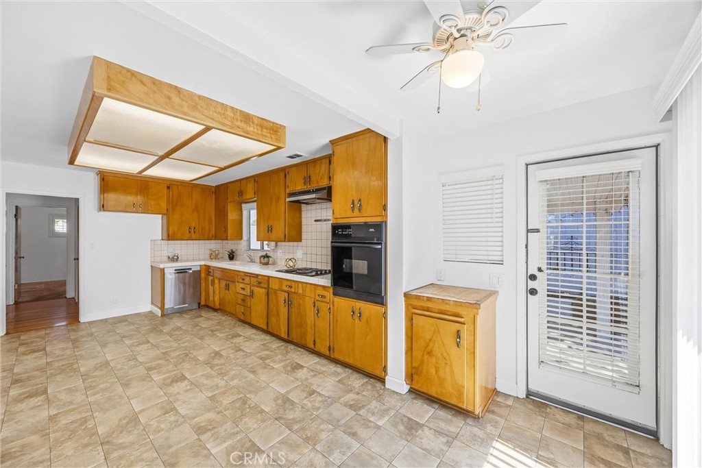 6730 Montclair Drive Riverside, CA 92504 - Photo 13 of 50 Spacious kitchen with classic wood cabinetry, generous storage, tile flooring, and convenient backyard access