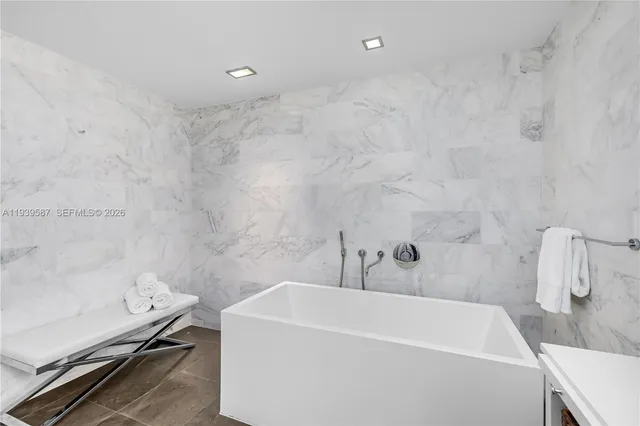 a bathroom with a white bath tub and a shower