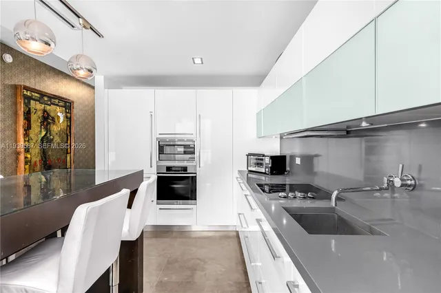 a kitchen with stainless steel appliances kitchen island granite countertop a sink and refrigerator