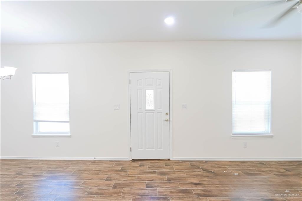 1046 Hidalgo Street Mercedes, TX 78570 - Photo 3 of 21 an empty room with wooden floor and windows