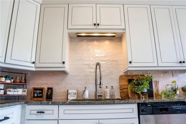 a kitchen with stainless steel appliances granite countertop white cabinets and a granite counter tops