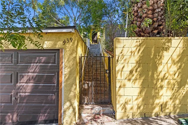 a view of backyard with table and chairs and potted plants