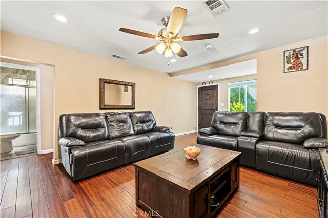 a living room with furniture flat screen tv and wooden floor