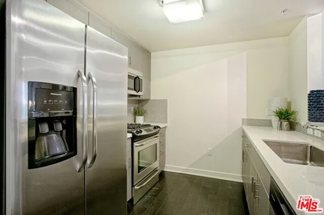 a kitchen that has a sink a refrigerator and a sink
