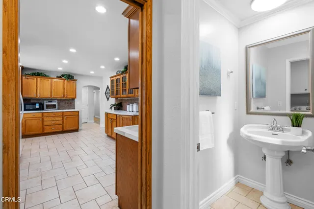 a view of a kitchen with kitchen island granite countertop a refrigerator and a sink
