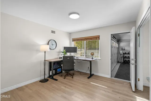 a view of a workspace with furniture and a window