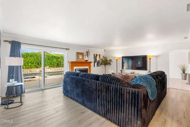 a living room with furniture a flat screen tv and a large window