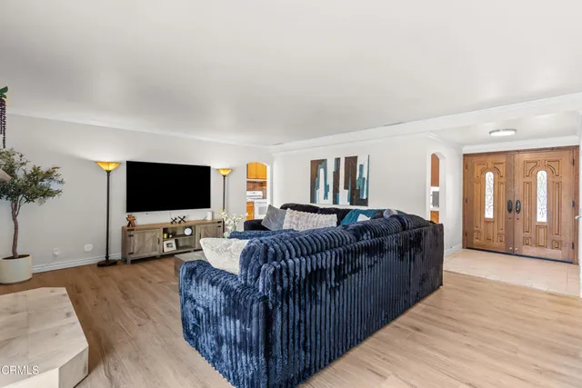 a living room with furniture a flat screen tv and a large window