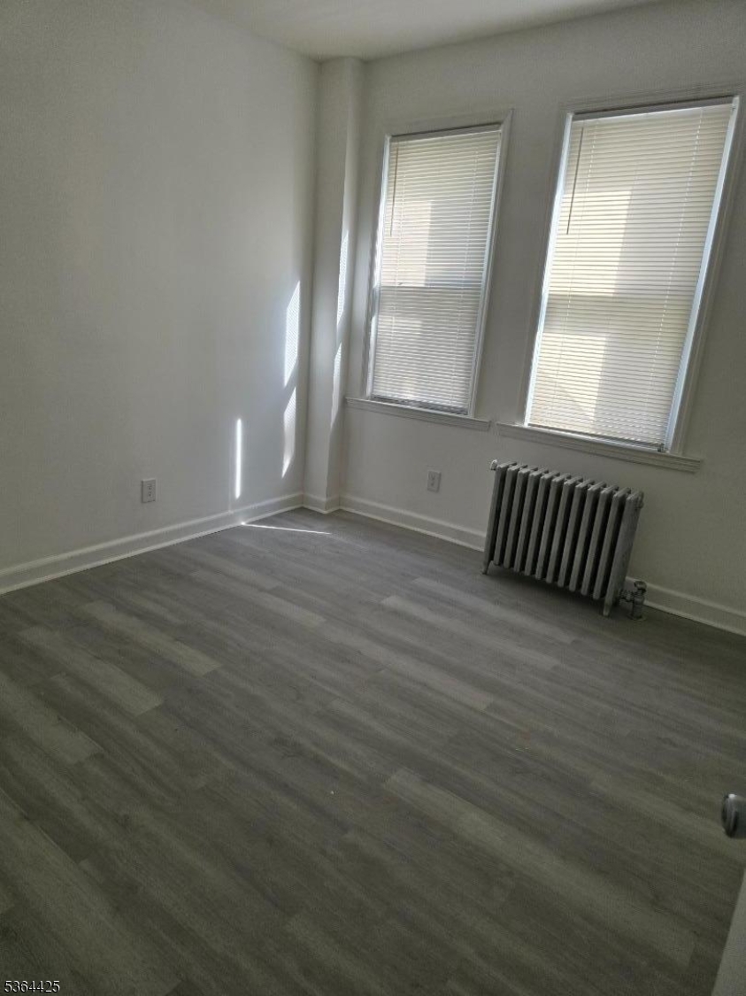782 Bergen Street, Unit 3 Newark, NJ 07108 - Photo 13 of 20 an empty room with wooden floor and windows