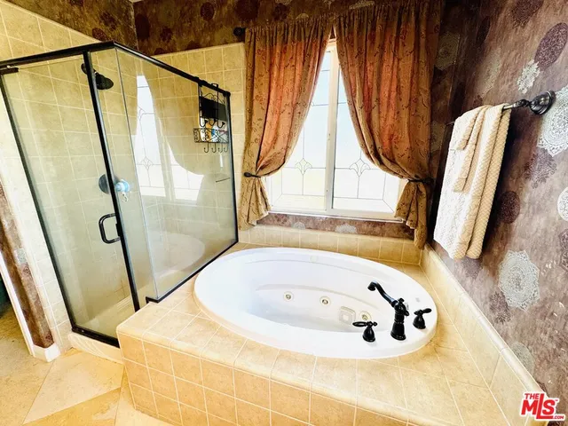 a bathroom with a tub a sink and a large mirror