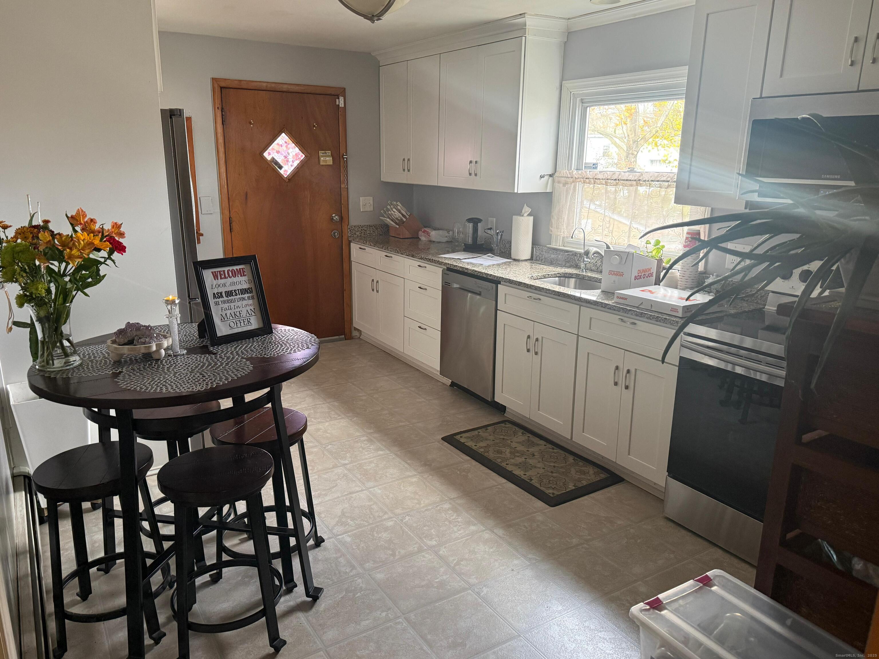 720 Queen Street Bridgeport, CT 06606 - Photo 30 of 36 a kitchen with stainless steel appliances granite countertop table chairs sink and cabinets