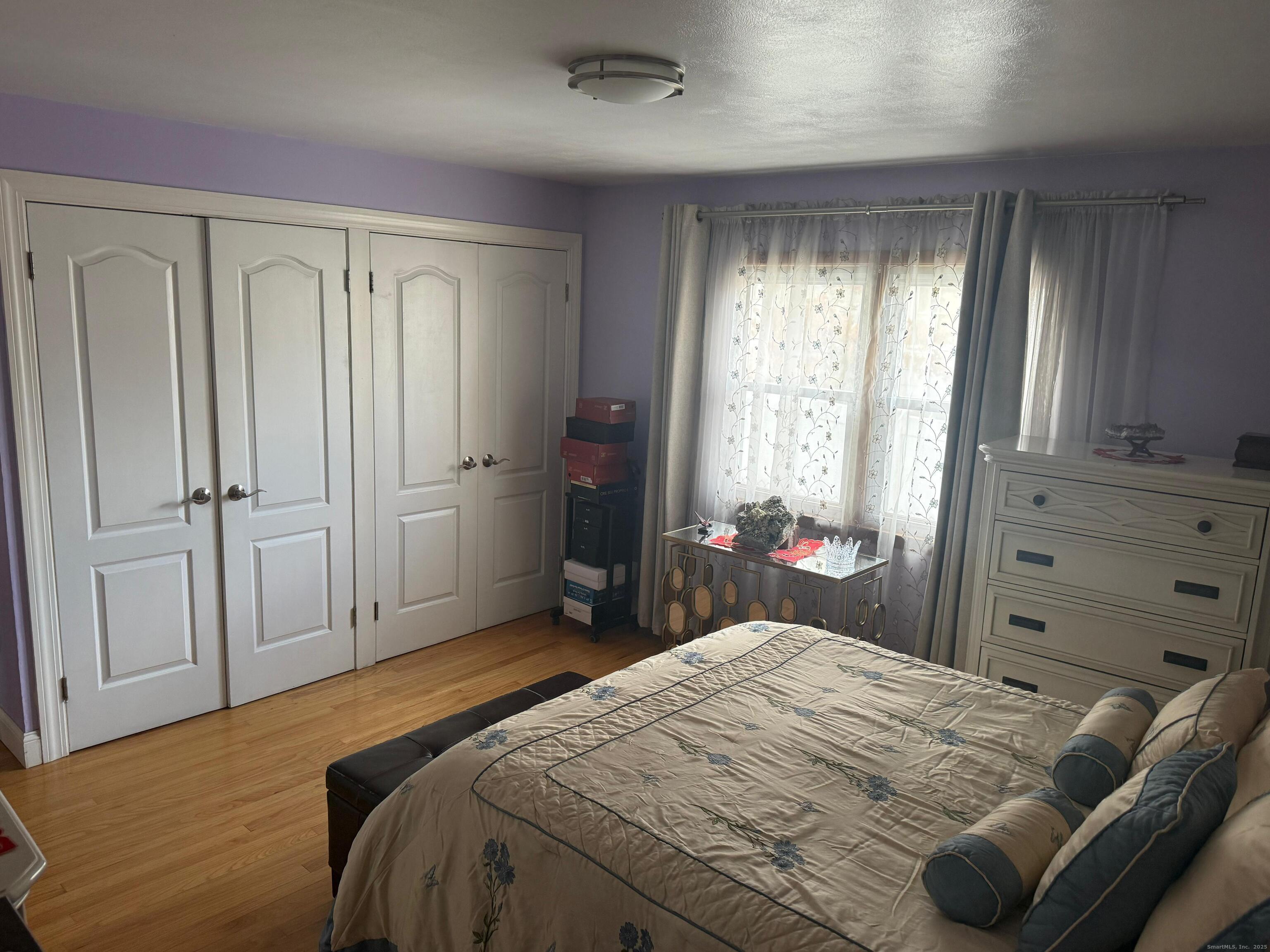 720 Queen Street Bridgeport, CT 06606 - Photo 32 of 36 a bedroom with a bed and a closet with wooden floor