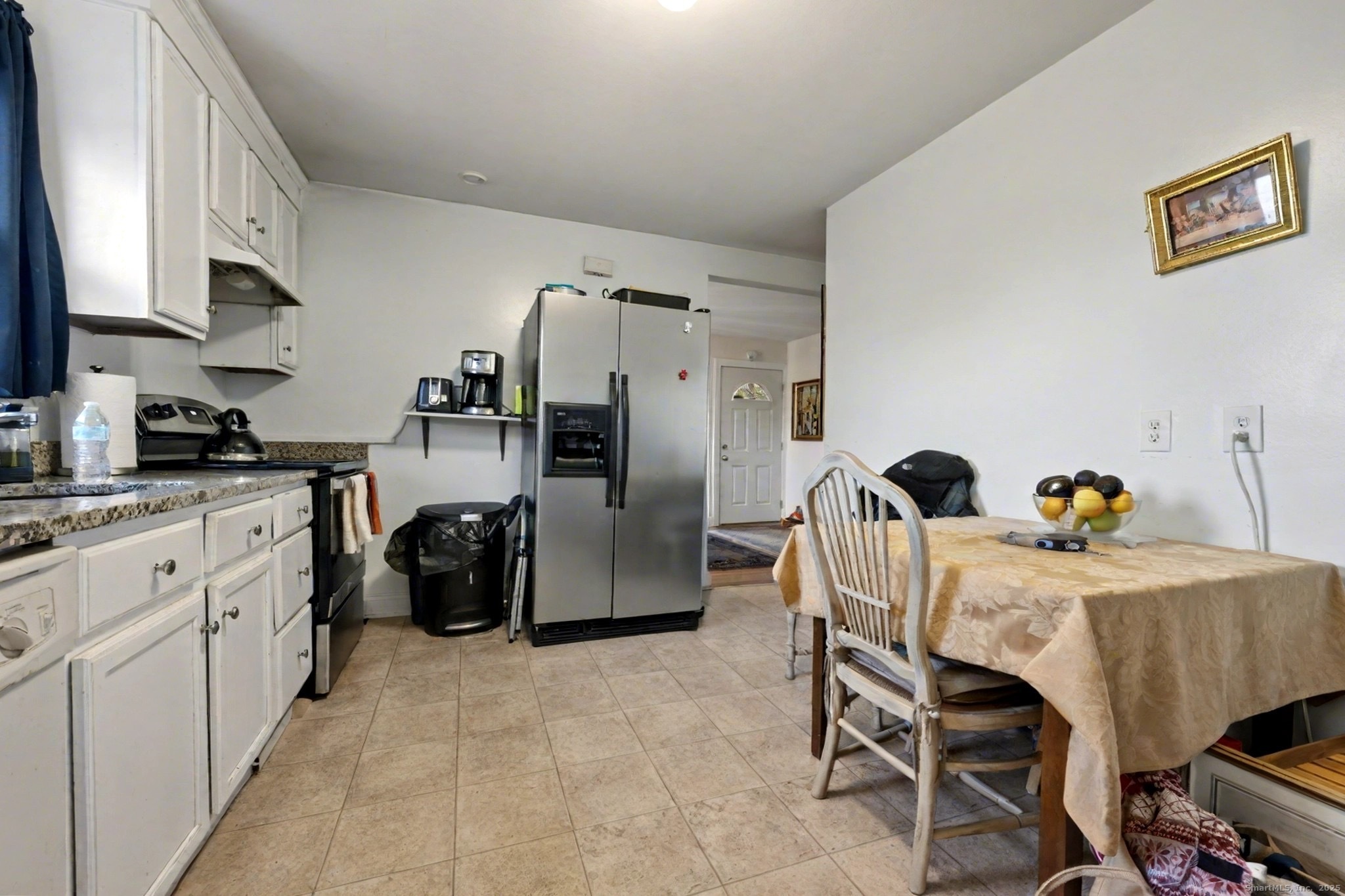 720 Queen Street Bridgeport, CT 06606 - Photo 9 of 36 a kitchen with stainless steel appliances a refrigerator a stove a sink a dining table and chairs