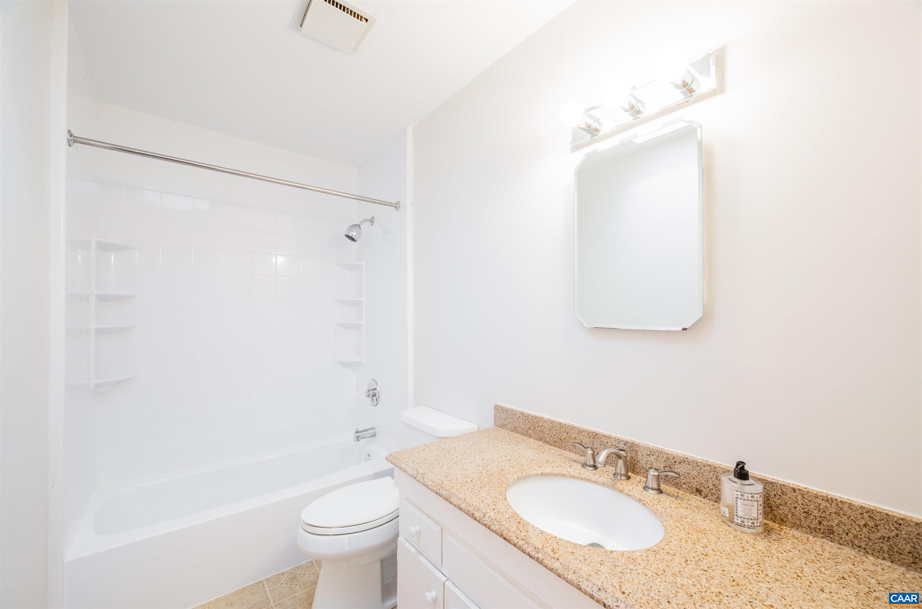 5688 Advance Mills Road Ruckersville, VA 22968 - Photo 25 of 52 a bathroom with a granite countertop sink a toilet and a mirror