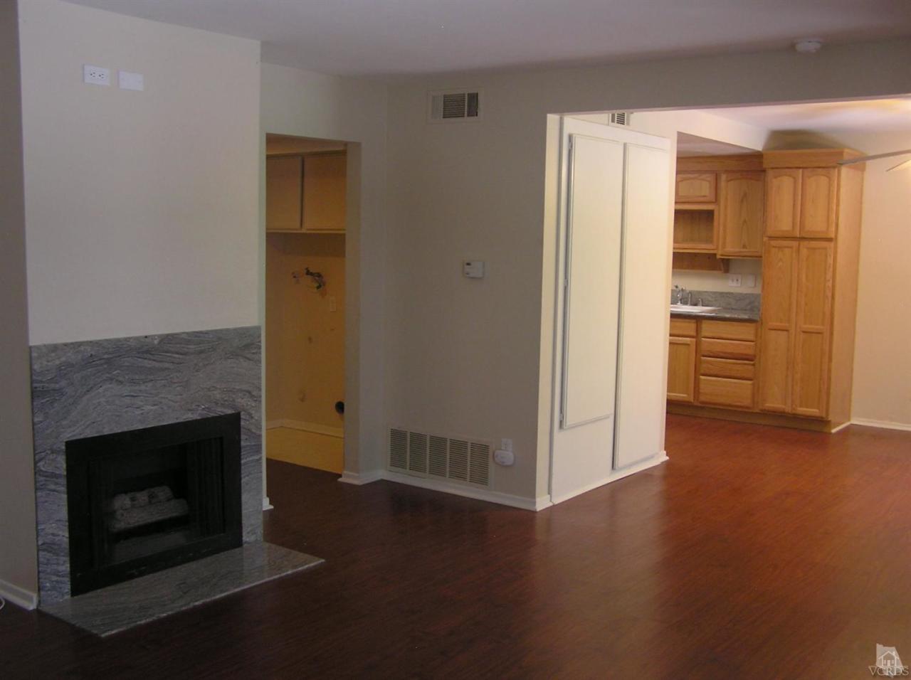516 Spring Road, Unit 114 Moorpark, CA 93021 - Photo 4 of 13 a view of a livingroom with wooden floor and a fireplace