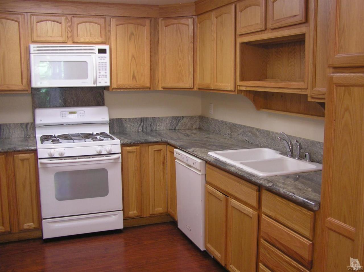516 Spring Road, Unit 114 Moorpark, CA 93021 - Photo 5 of 13 a kitchen with granite countertop a sink stove and cabinets