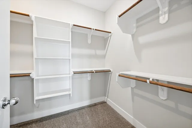 a view of walk in closet with empty racks