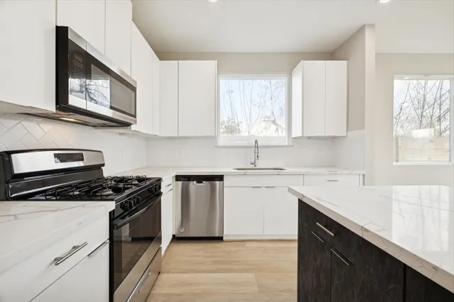 a kitchen with cabinets appliances a sink and a window