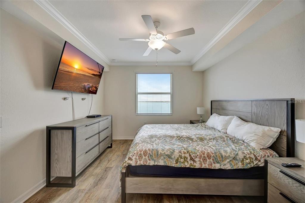 910 Tidewater Shores Loop, Unit 304 Bradenton, FL 34208 - Photo 14 of 42 a bedroom with a bed and a flat screen tv