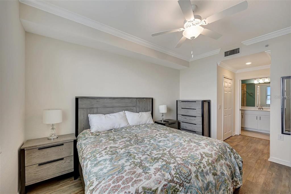 910 Tidewater Shores Loop, Unit 304 Bradenton, FL 34208 - Photo 15 of 42 a bedroom with a bed and a chandelier