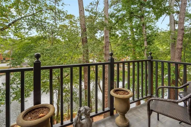 a view of a balcony with chair and large trees