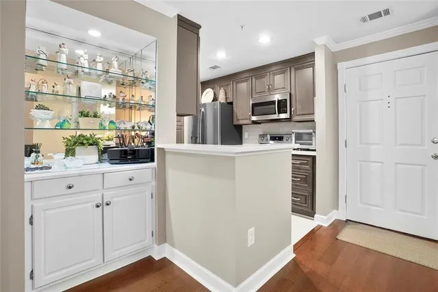 a kitchen with white cabinets and refrigerator