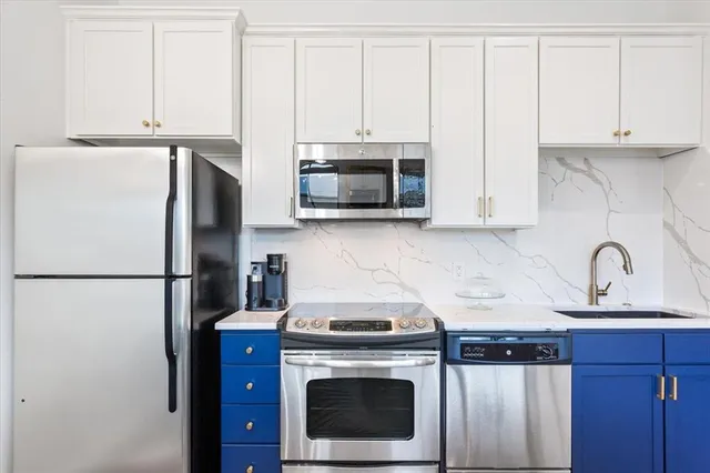 a kitchen with stainless steel appliances a stove a microwave and a refrigerator