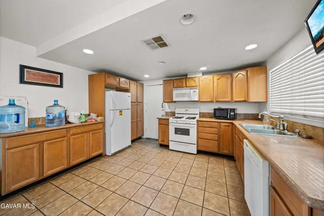 a kitchen with a sink appliances cabinets and furniture