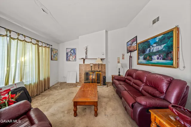 a living room with furniture a fireplace and large windows