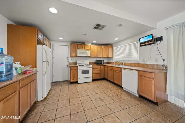 a kitchen with cabinets a sink and white stainless steel appliances