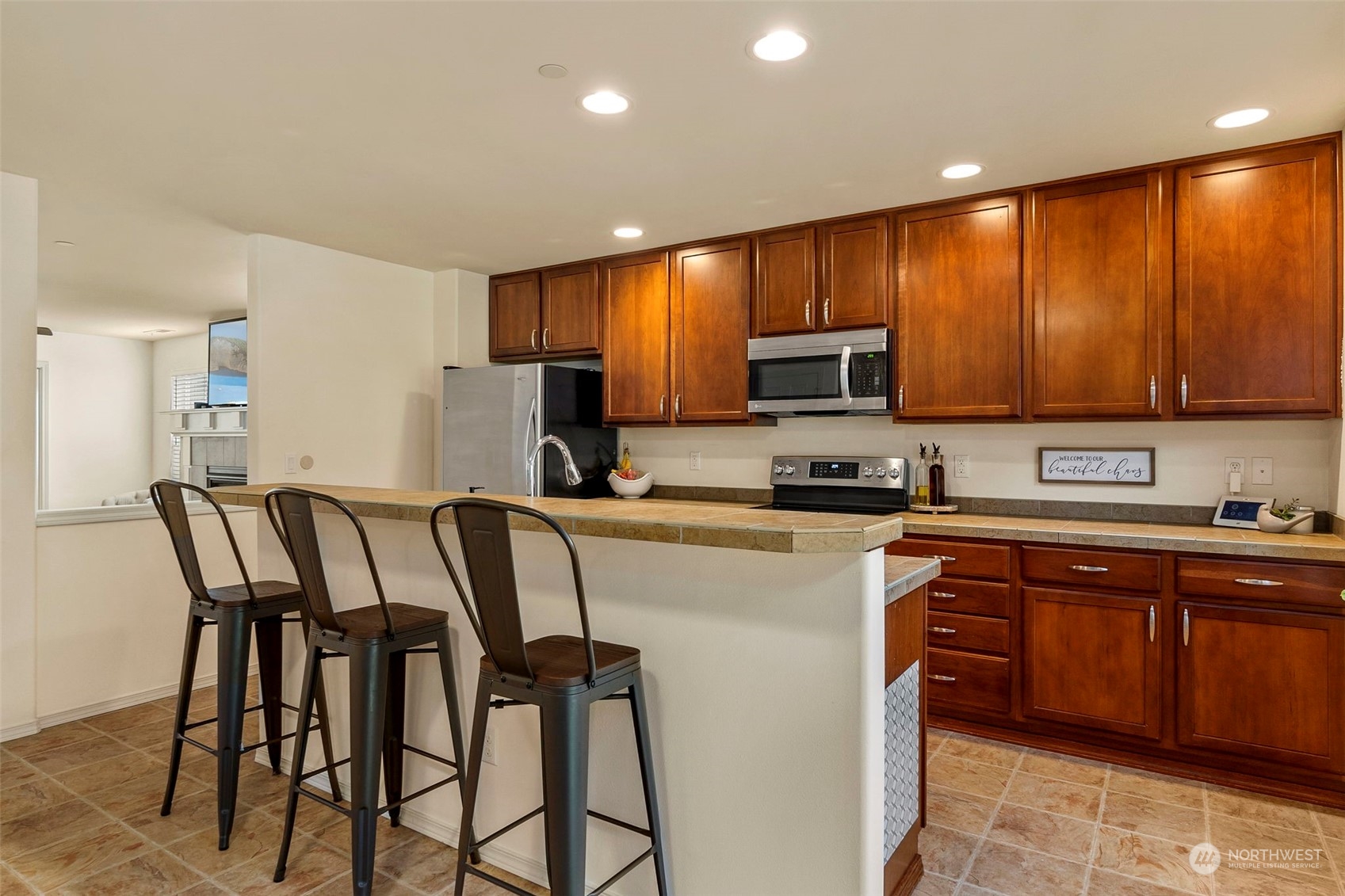 1328 Foreman Road DuPont, WA 98327 - Photo 13 of 37 a kitchen with a dining table chairs refrigerator and microwave