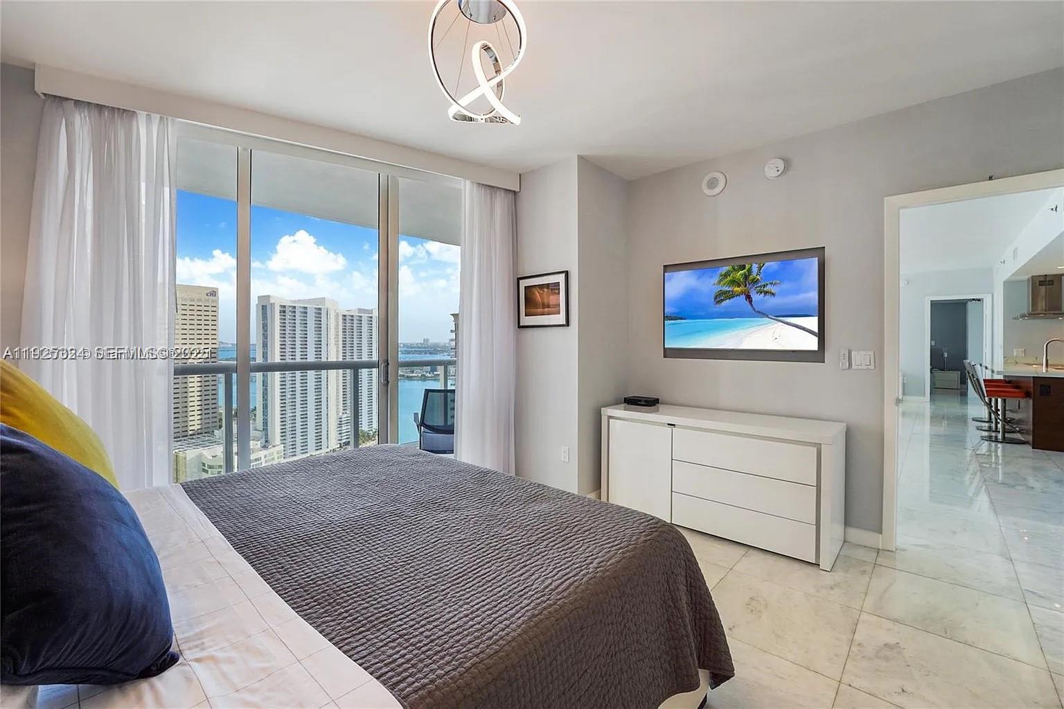 495 Brickell Avenue, Unit 3304 Miami, FL 33131 - Photo 15 of 28 a bedroom with a bed and a chandelier