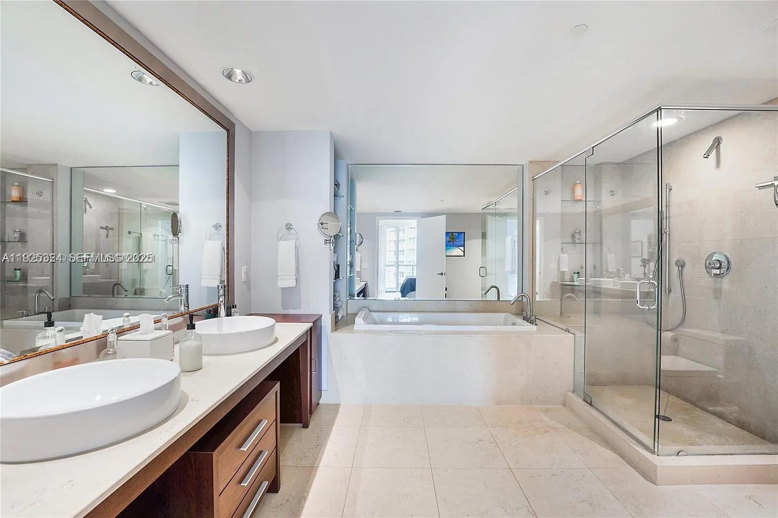 495 Brickell Avenue, Unit 3304 Miami, FL 33131 - Photo 16 of 28 a spacious bathroom with a shower sink and mirror