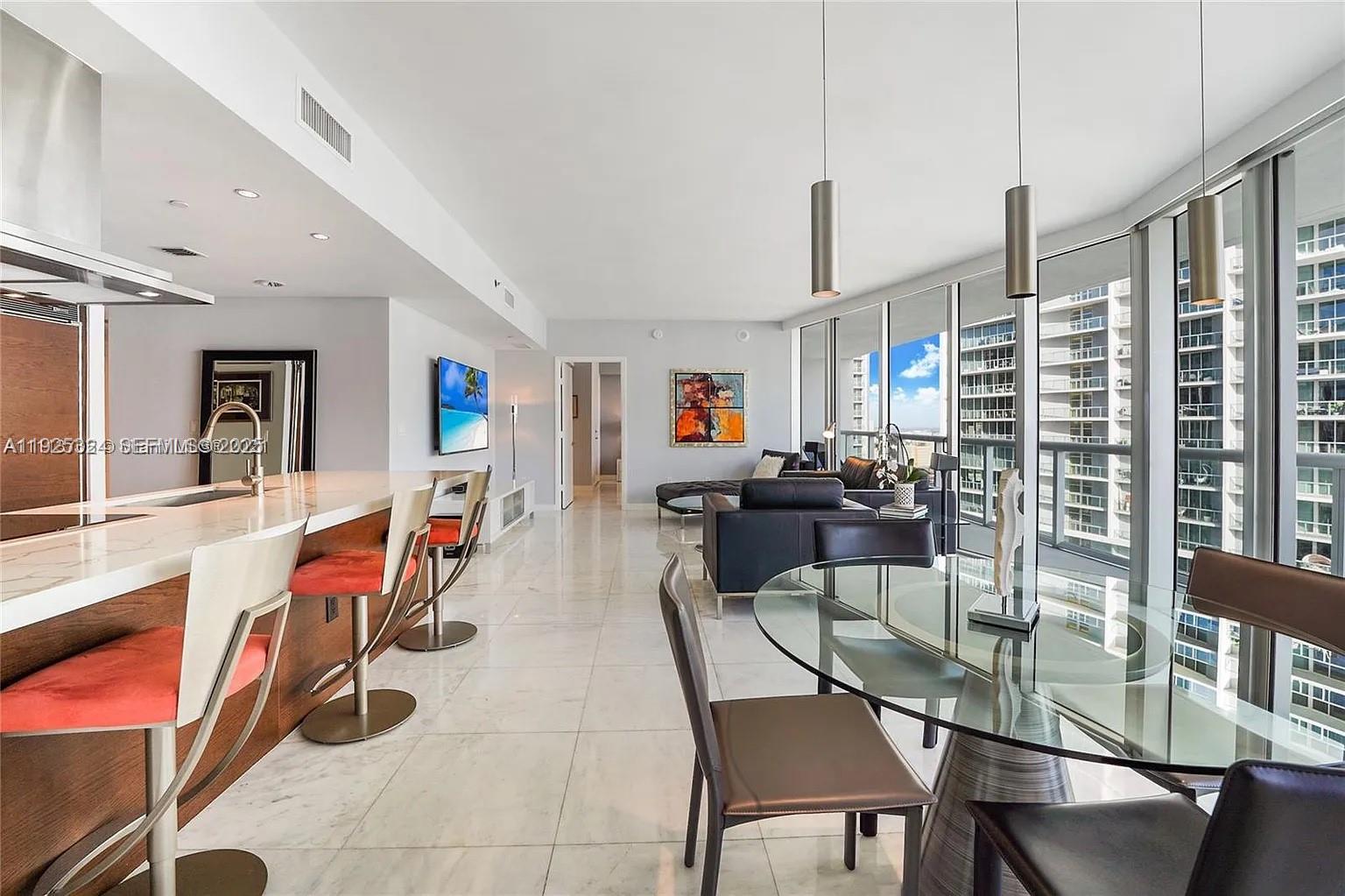 495 Brickell Avenue, Unit 3304 Miami, FL 33131 - Photo 8 of 28 a dining room with stainless steel appliances a dining table and chairs with the wooden floor