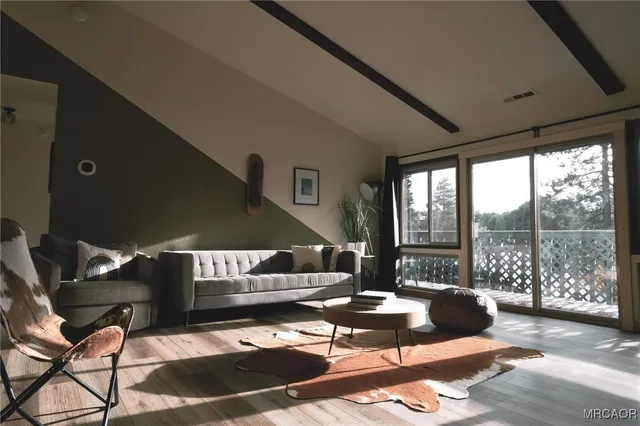 a living room with furniture and a floor to ceiling window