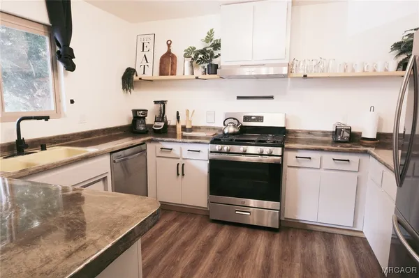 a kitchen with kitchen island a stove a sink and wooden floor