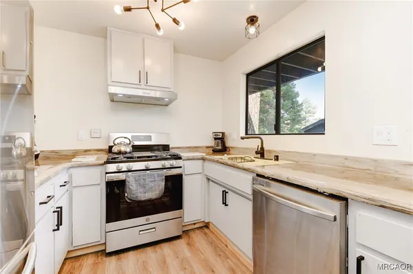 a kitchen with stainless steel appliances granite countertop a sink stove and cabinets