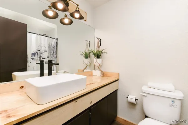 a bathroom with a sink a toilet and a mirror